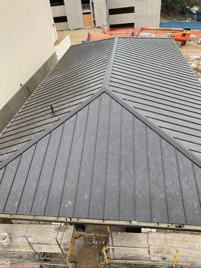 Commercial metal roof construction with crane equipment in Cicero